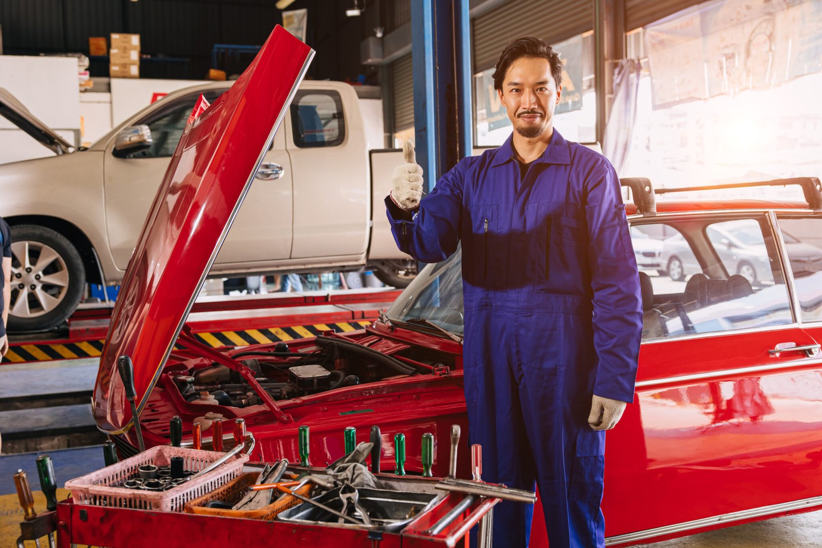 Portrait Asian Japanese male mechanic worker portrait in auto service workshop car maintenance center replace fix auto engine part